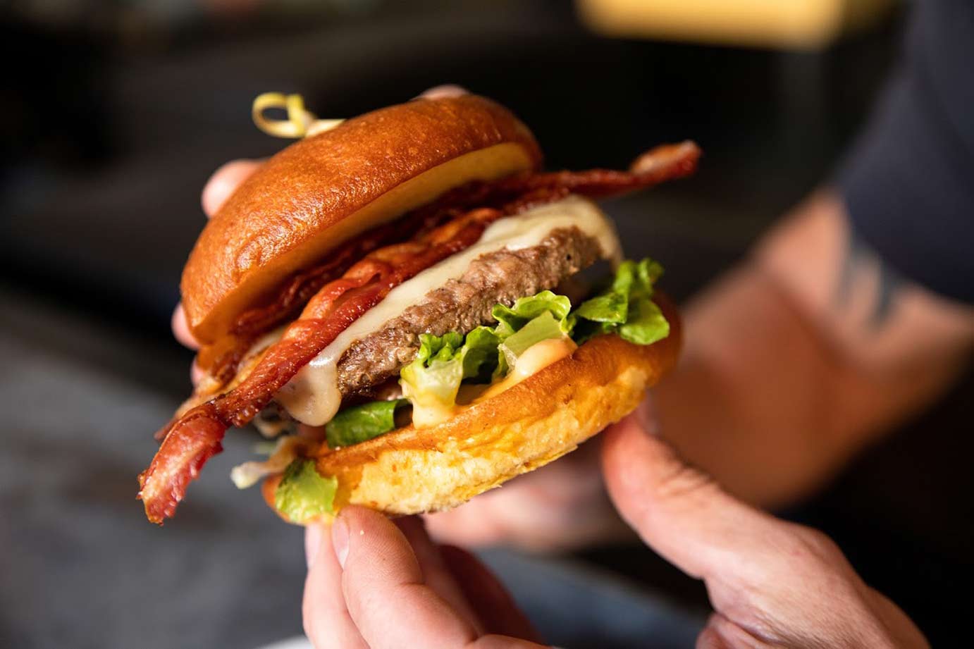 Hands holding cheeseburger